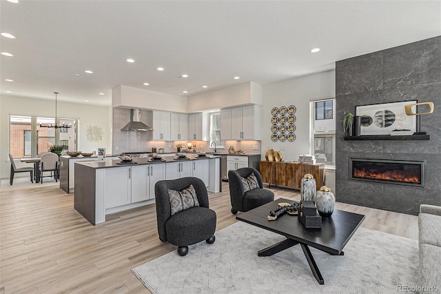 living room featuring a fireplace, light hardwood / wood-style floors, and sink