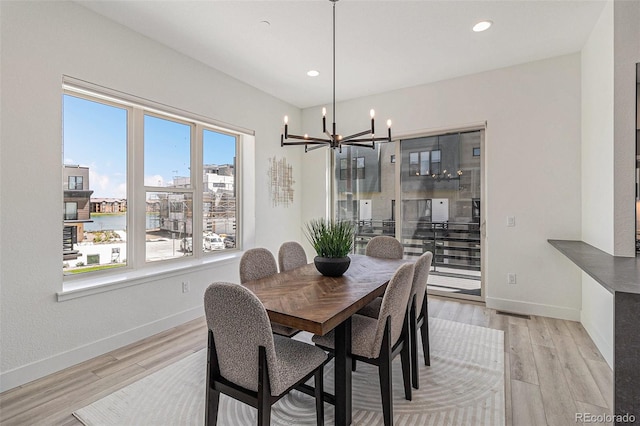 dining area featuring a notable chandelier and light wood-type flooring