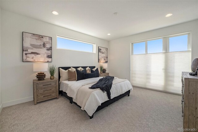 bedroom with multiple windows and light colored carpet