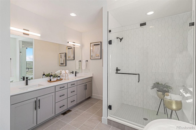 bathroom with tile patterned flooring, vanity, and a shower with door