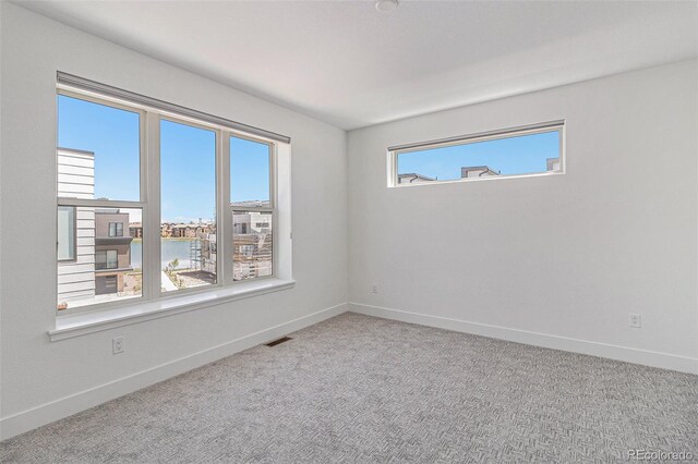 spare room featuring carpet flooring and a water view