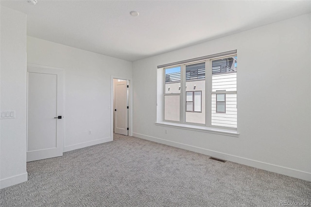 unfurnished room featuring light colored carpet