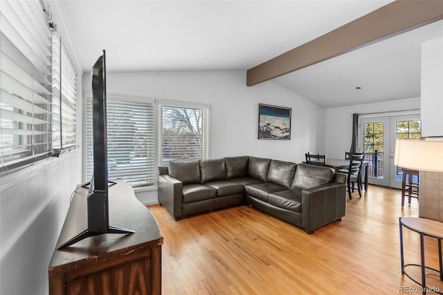 living room with hardwood / wood-style flooring, lofted ceiling with beams, and french doors