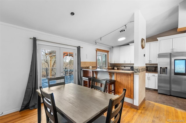 kitchen featuring white cabinetry, french doors, a breakfast bar, and stainless steel refrigerator with ice dispenser