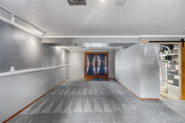 basement with rail lighting and carpet floors