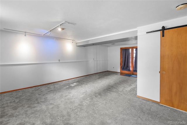 interior space with rail lighting, a barn door, and carpet floors