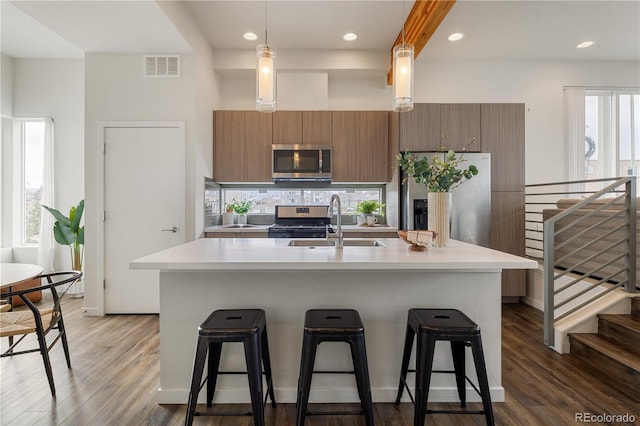 kitchen featuring light countertops, appliances with stainless steel finishes, visible vents, and brown cabinets