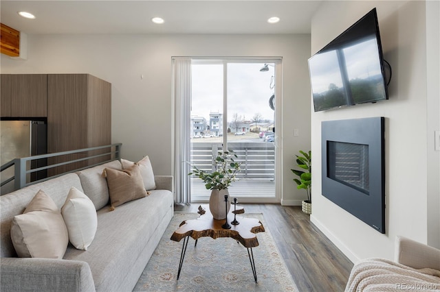 living room with baseboards, dark wood-style flooring, a fireplace, and recessed lighting