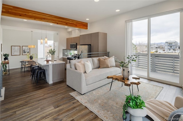 living area featuring dark wood-style floors, baseboards, beam ceiling, and recessed lighting