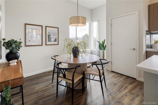 dining space with dark wood finished floors and baseboards