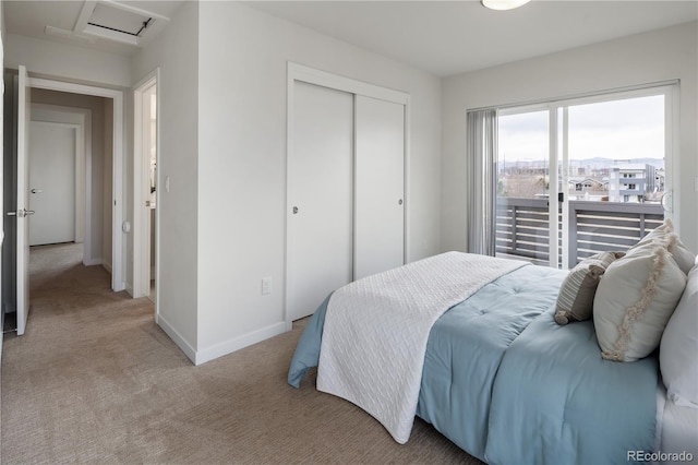 bedroom with light carpet, attic access, baseboards, and a closet