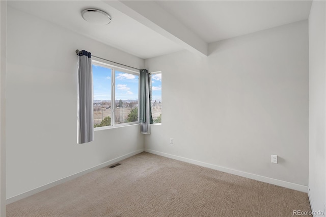 unfurnished room with carpet, visible vents, beamed ceiling, and baseboards