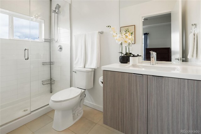 bathroom with toilet, tile patterned flooring, vanity, and a shower stall