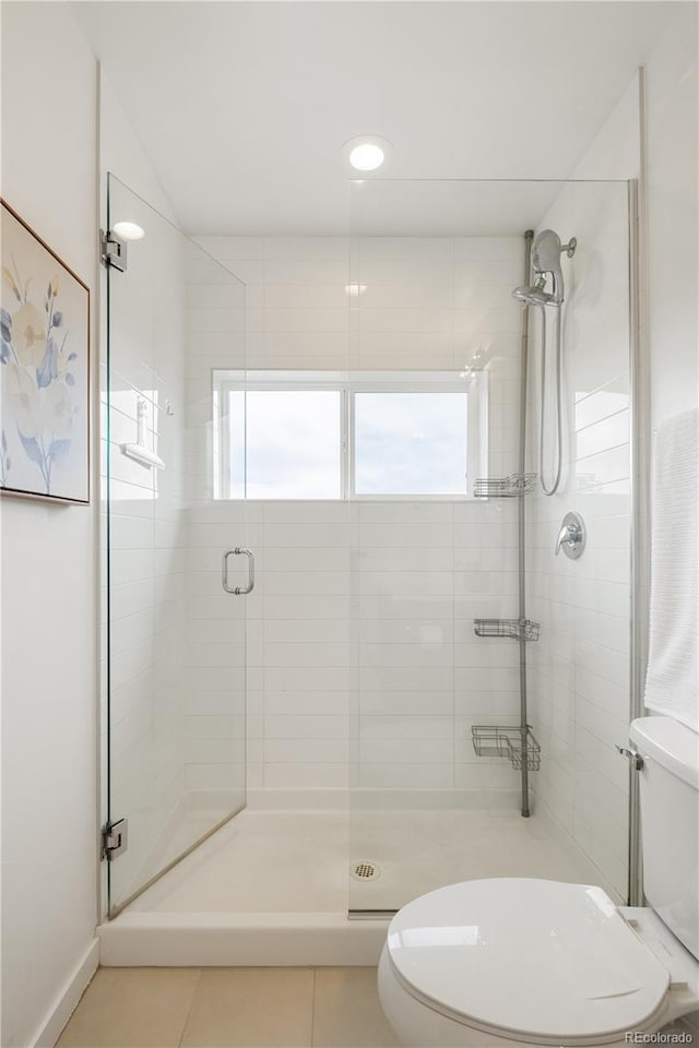 full bathroom featuring a shower stall, toilet, and tile patterned floors