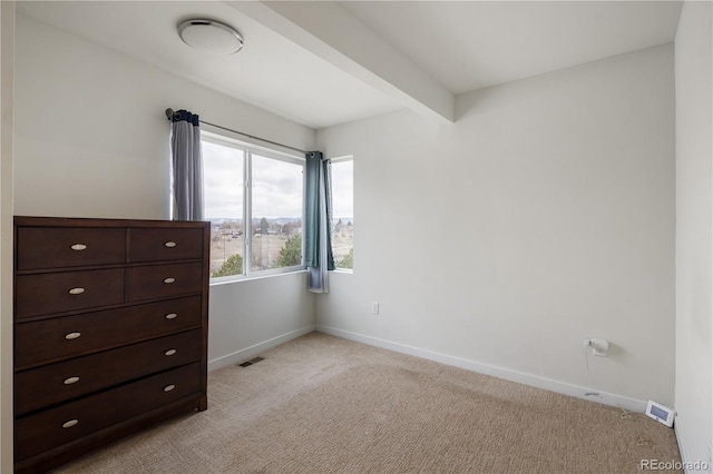 unfurnished bedroom with light carpet, visible vents, baseboards, and beam ceiling