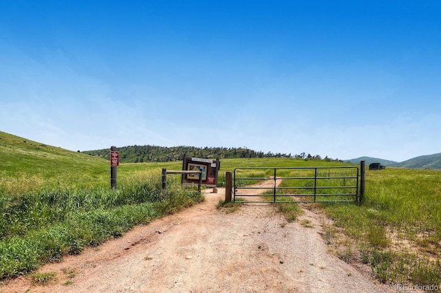 view of gate with a mountain view and a rural view