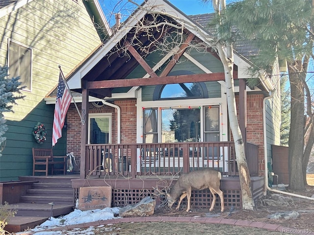 view of front of property featuring brick siding and covered porch