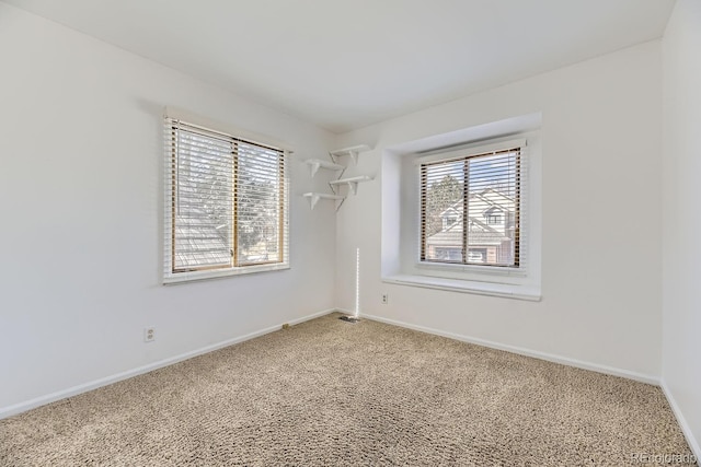 unfurnished room featuring light colored carpet and baseboards