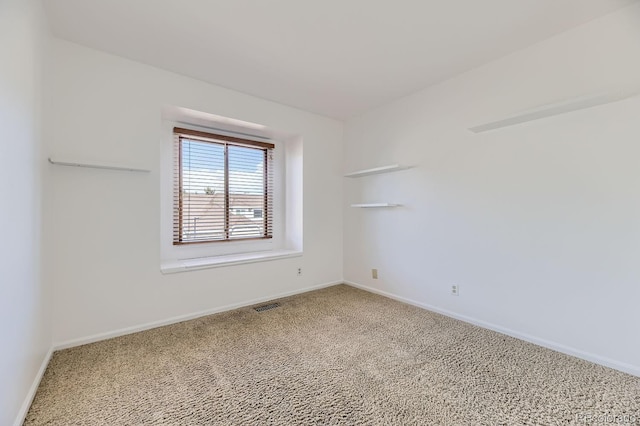 carpeted empty room featuring baseboards and visible vents