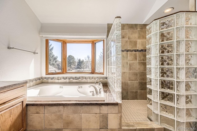 bathroom with lofted ceiling, a garden tub, and a walk in shower