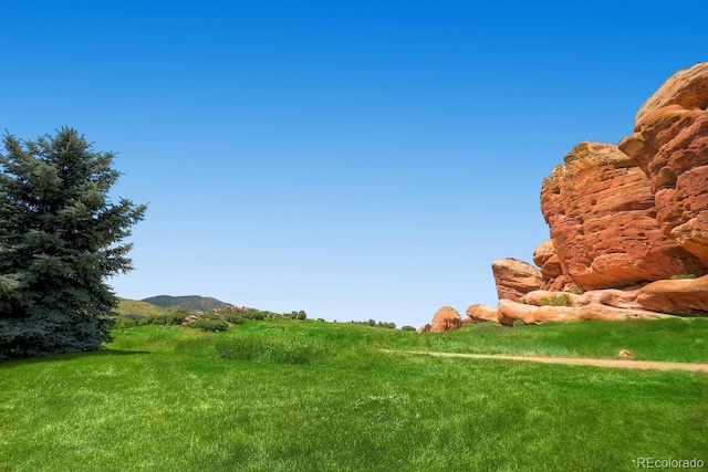 view of community featuring a lawn and a mountain view