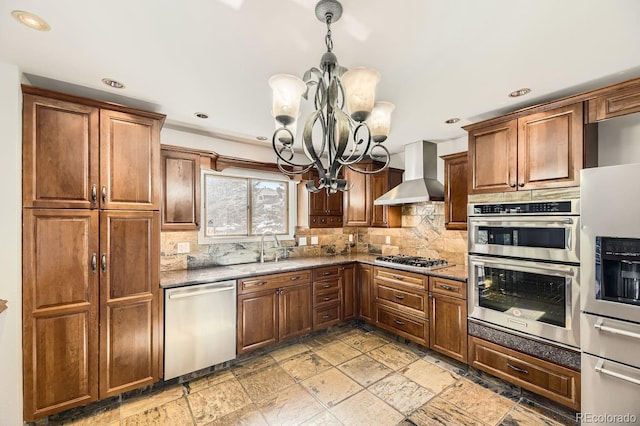 27 Buckthorn Dr, Littleton, CO 80127 - kitchen with tasteful backsplash, a notable chandelier, wall chimney exhaust hood, appliances with stainless steel finishes, and a sink