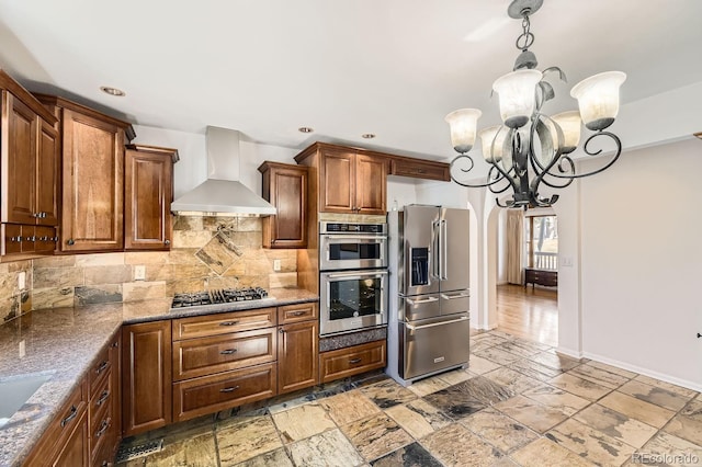 27 Buckthorn Dr, Littleton, CO 80127 - kitchen with stone countertops, a notable chandelier, wall chimney exhaust hood, decorative backsplash, and stainless steel appliances