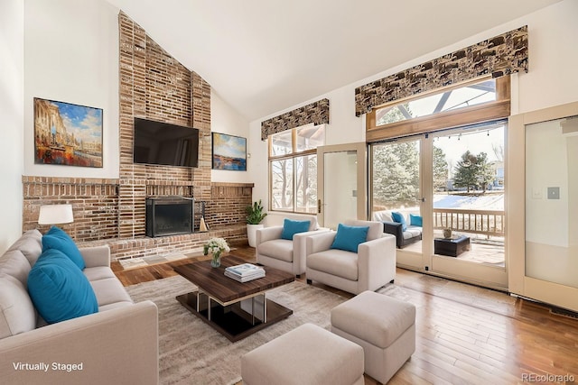 27 Buckthorn Dr, Littleton, CO 80127 - living room featuring high vaulted ceiling, plenty of natural light, wood-type flooring, and a fireplace