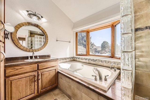 27 Buckthorn Dr, Littleton, CO 80127 - bathroom featuring a garden tub, vanity, tile patterned flooring, and vaulted ceiling