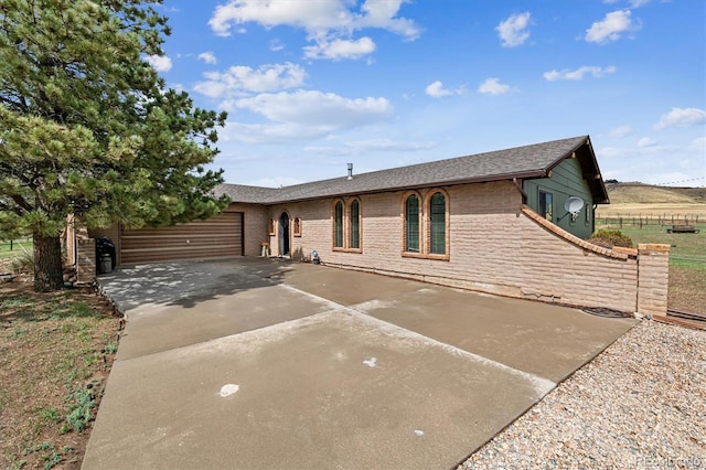 5300 Norwood Ave, Loveland, CO 80538 - ranch-style home with driveway, a garage, brick siding, fence, and roof with shingles