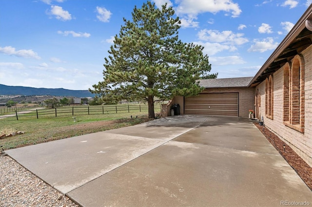 view of patio featuring a mountain view, a rural view, and a garage