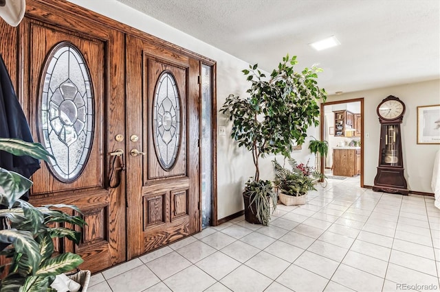 entrance foyer with a textured ceiling and light tile patterned flooring