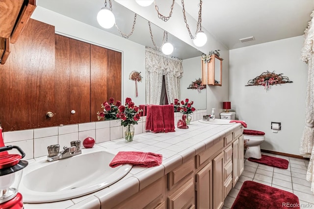 bathroom featuring toilet, vanity, and tile patterned floors