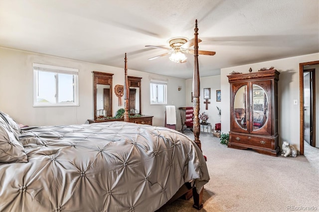 carpeted bedroom featuring ceiling fan and a textured ceiling