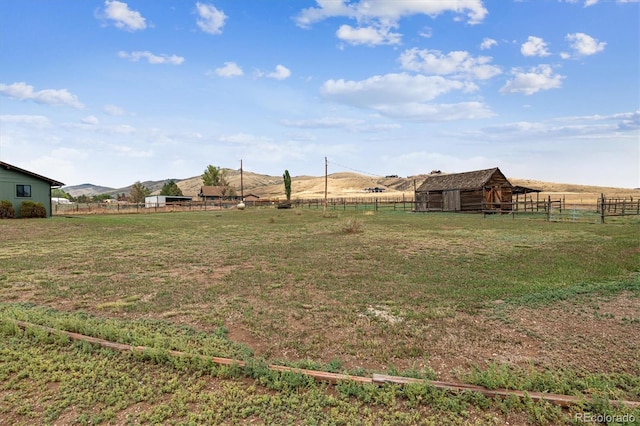 view of yard with a mountain view, a rural view, and an outdoor structure