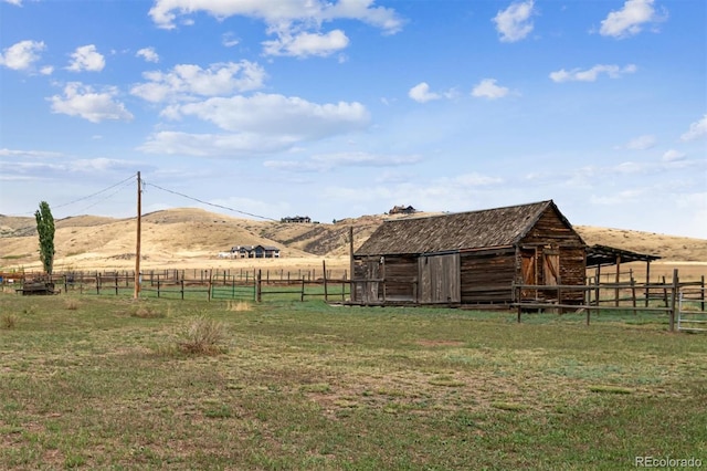 view of stable with a mountain view and a rural view