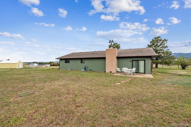 rear view of property featuring a patio area and a yard