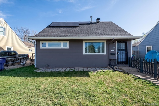 1680 W Mexico Ave, Denver, CO 80223 - back of property with a yard, roof mounted solar panels, roof with shingles, and a fenced backyard