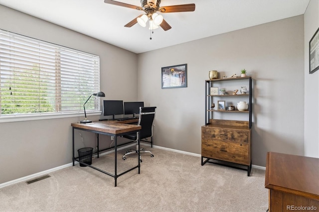 office area with a ceiling fan, light colored carpet, and baseboards