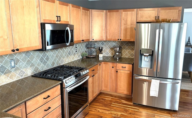 16662 W 61st Pl, Arvada, CO 80403 - kitchen featuring appliances with stainless steel finishes, wood finished floors, dark stone countertops, and backsplash