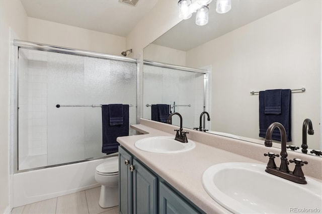 16662 W 61st Pl, Arvada, CO 80403 - bathroom with toilet, combined bath / shower with glass door, double vanity, and tile patterned flooring