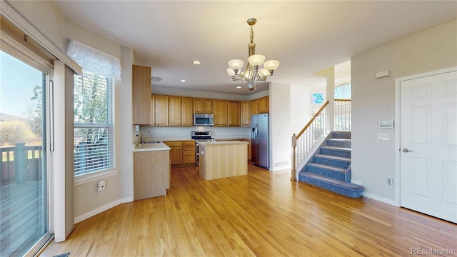 kitchen featuring a sink, light countertops, a chandelier, plenty of natural light, and stainless steel appliances