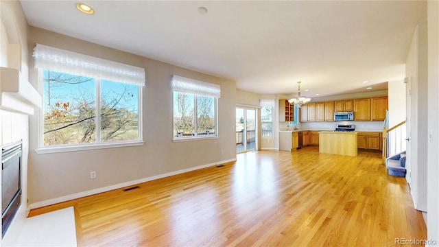 kitchen with visible vents, appliances with stainless steel finishes, light countertops, a chandelier, and light wood-style flooring