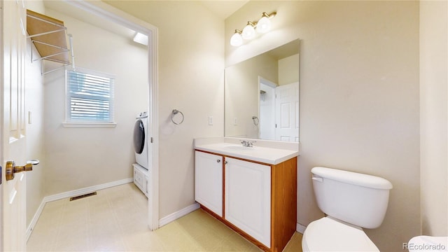 bathroom featuring washer / clothes dryer, visible vents, vanity, baseboards, and toilet