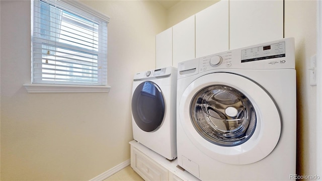 laundry area with washer and dryer, a healthy amount of sunlight, and cabinet space