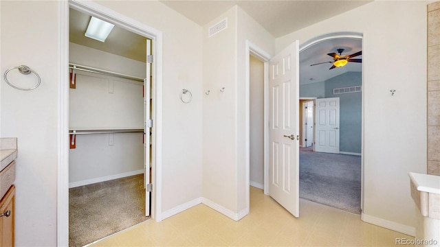 bathroom featuring vanity, a ceiling fan, a spacious closet, and visible vents