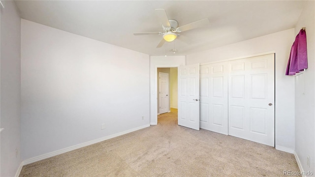 unfurnished bedroom featuring carpet floors, baseboards, ceiling fan, and a closet