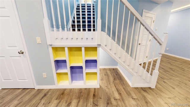 staircase featuring baseboards and wood finished floors