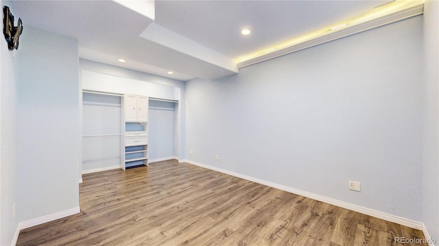 unfurnished bedroom featuring baseboards, recessed lighting, and wood finished floors