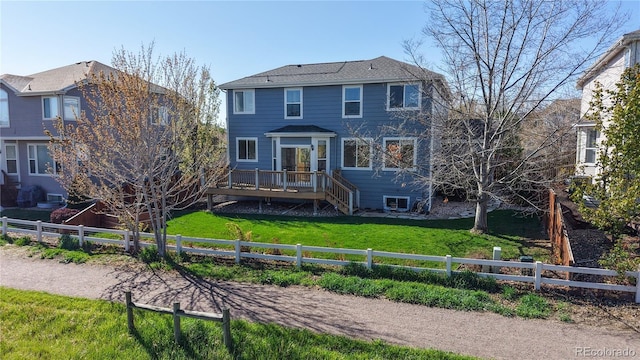 view of front of home featuring a deck, a shingled roof, a fenced backyard, and a front lawn